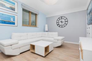 a white living room with a white couch and a table at Apartment na poziomie -1 w Luksusowym Domu Posejdon by Renters Prestige in Kołczewo