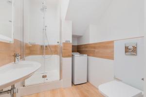 a white bathroom with a sink and a shower at Underground Apartment in a Lux Holiday House Posejdon by Renters Prestige in Kołczewo