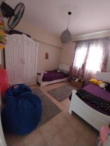 a bedroom with two beds and a large window at Green leaves Challet North Coast k75 in Dawwār Muḩammad Abū Shunaynah +20 photos