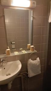 La salle de bains est pourvue d'un lavabo, d'un miroir et d'une serviette. dans l'établissement Logis Hotel des Portes de Meuse, à Pagny-sur-Meuse