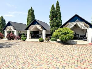 a house with trees and a brick driveway at Koral Hotel in Verkhniy Koropets