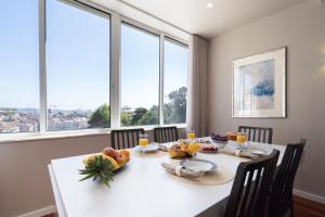 a dining room with a white table with fruit on it at Carolina Roomy & Modern Apartment in Porto