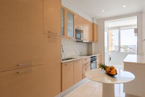 a kitchen with a table with a bowl of fruit on it at Carolina Roomy & Modern Apartment in Porto
