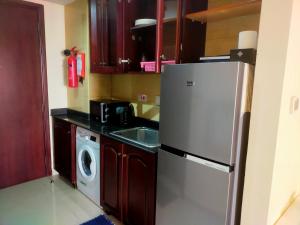 a kitchen with a refrigerator and a washing machine at Sea View Studio 3 Royal Breeze Breezeسي ويو ستوديو رويال بريز in Ras al Khaimah