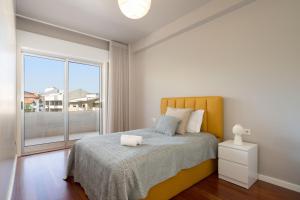 um quarto com uma cama e uma grande janela em Carolina Roomy & Modern Apartment em Porto