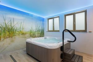 a large bath tub in a room with windows at Underground Apartment in a Lux Holiday House Posejdon by Renters Prestige in Kołczewo