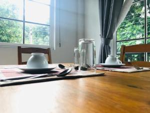 a wooden table with plates and utensils on it at Kandy Traveller's Cottage in Kandy