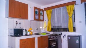 una cucina con armadi in legno e piano cottura. di One Bed Garden Estate Nairobi a Nairobi