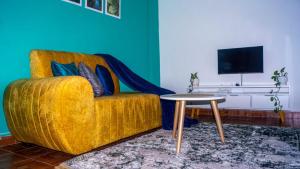 un soggiorno con divano giallo e tavolo di One Bed Garden Estate Nairobi a Nairobi
