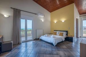 a large bedroom with a bed and a balcony at Tonia's Residential Villa in Kissamos