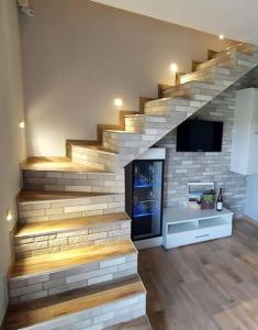 a living room with a staircase with a tv on the wall at Domki Całoroczne Południowy Stok in Gródek Nad Dunajcem