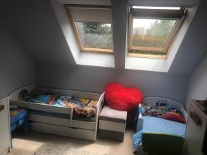 a attic room with two twin beds and two windows at Zaciszny dom in Szczecin
