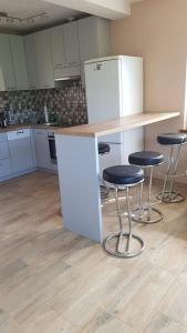 a kitchen with two stools and a counter with a refrigerator at Domki Całoroczne Południowy Stok in Gródek Nad Dunajcem