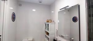a white bathroom with a mirror and a toilet at Mar Salada in L'Ametlla de Mar