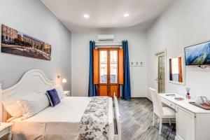 a bedroom with a bed and a desk and a table at Agorà Borsa in Naples