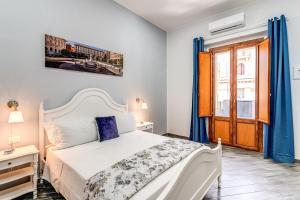 1 dormitorio con cama blanca y ventana en Agorà Borsa, en Nápoles