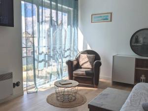 ein Wohnzimmer mit einem Stuhl und einem Fenster in der Unterkunft Beau studio à deux pas de la gare - Kerlaouen in Saint-Brieuc