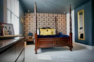 Sway的住宿－Hazelhurst Farm，一间卧室设有天蓬床和蓝色的墙壁
