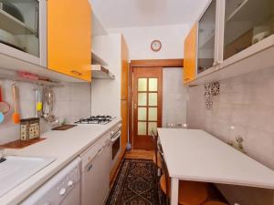 eine Küche mit weißen Arbeitsplatten und gelben Schränken in der Unterkunft Nel cuore dell'Appia Antica in Rom