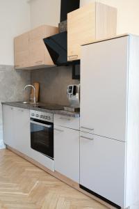 uma cozinha com armários brancos e um frigorífico branco em Belvedere Apartment em Viena