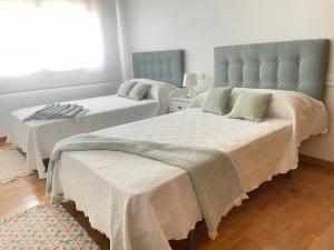 1 Schlafzimmer mit 2 Betten und einem Fenster in der Unterkunft Piso Sirius in Vilagarcia de Arousa