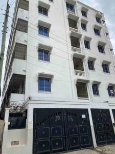 a large white building with black garage doors at Kwetu House in Mombasa