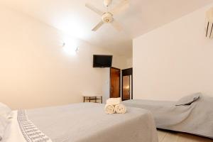 1 dormitorio con 2 camas y ventilador de techo en Hotel Marciala en Villa Carlos Paz