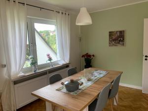 een eetkamer met een houten tafel en een raam bij Stadtperle Sundern in Sundern