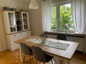 a kitchen with a wooden table and chairs and a window at Stadtperle Sundern in Sundern