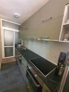 uma cozinha com armários brancos e um balcão preto em Fantastic 2 bedroom Apartment em Tirana