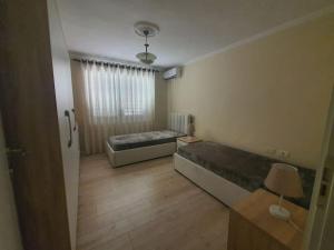um quarto com 2 camas e uma janela em Fantastic 2 bedroom Apartment em Tirana