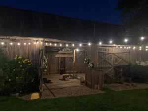 a patio with lights on a fence at night at Kolonia u Jasia Rajgród in Rajgród