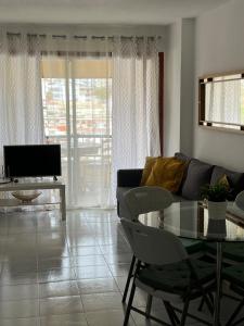 een woonkamer met een bank en een tafel bij Torres Del Sol , Las Americas , cute apartment in Arona