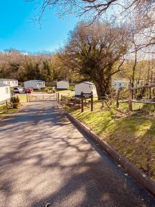 una strada con recinzione, albero e tende di Luxury Lodge Hoburne Devon Bay WG21 a Paignton