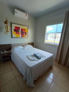 a bedroom with a bed with a towel on it at Hotel Indiana in Paragominas +16 photos