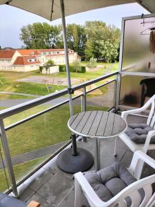 a patio with a table and chairs on a balcony at Silver Lotus 1 in De Haan +3 photos