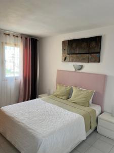 een slaapkamer met een wit bed met een roze hoofdeinde bij Torres Del Sol , Las Americas , cute apartment in Arona +10 foto's