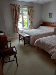 1 dormitorio con 2 camas, mesa y ventana en Villa Pio Accommodation, en Cong