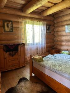 - une chambre avec un lit dans une cabane en rondins dans l'établissement Ultimate relaxation near Slovak Paradise, à Rožňava