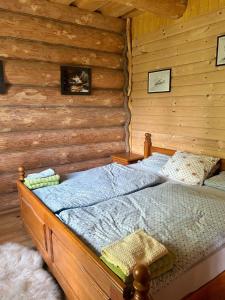 - une chambre avec un lit dans une cabane en rondins dans l'établissement Ultimate relaxation near Slovak Paradise, à Rožňava