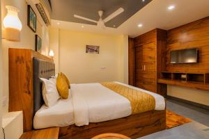 a bedroom with a large bed and a tv at MERIDIAN BY Daan in Trivandrum