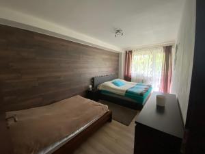 a small bedroom with two beds and a window at Apartmán s nádherným výhľadom na Tatry in Veľký Slavkov