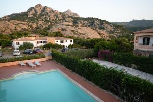 a house with a swimming pool and a mountain at Domus Smeralda in Porto Cervo