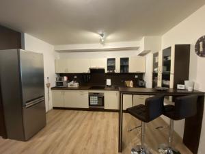 a kitchen with a stainless steel refrigerator and a table at Apartmán s nádherným výhľadom na Tatry in Veľký Slavkov