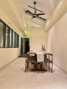 a dining room with a table and a ceiling fan at V Lodge in Kuantan