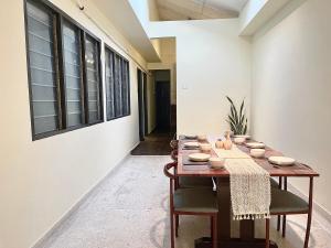a dining room with a wooden table and chairs at V Lodge in Kuantan