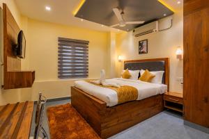 a bedroom with a bed and a television in it at MERIDIAN BY Daan in Trivandrum