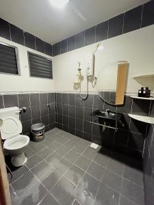 a bathroom with a shower and a toilet and a sink at V Lodge in Kuantan