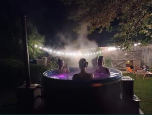 un groupe de personnes dans un bain à remous la nuit dans l'établissement Kolonia u Jasia Rajgród, à Rajgród
