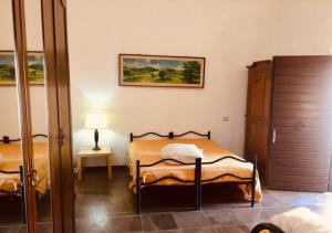 a bedroom with two beds and a painting on the wall at Agriturismo Il Geranio in Piccione